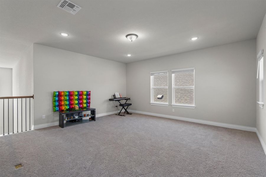 Recessed lighting and wall-to-wall carpeting define this versatile upper-level bonus space.