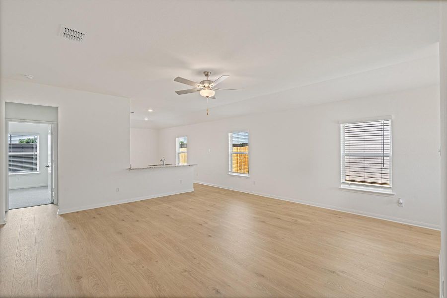 Unfurnished living room with ceiling fan and light wood-type flooring