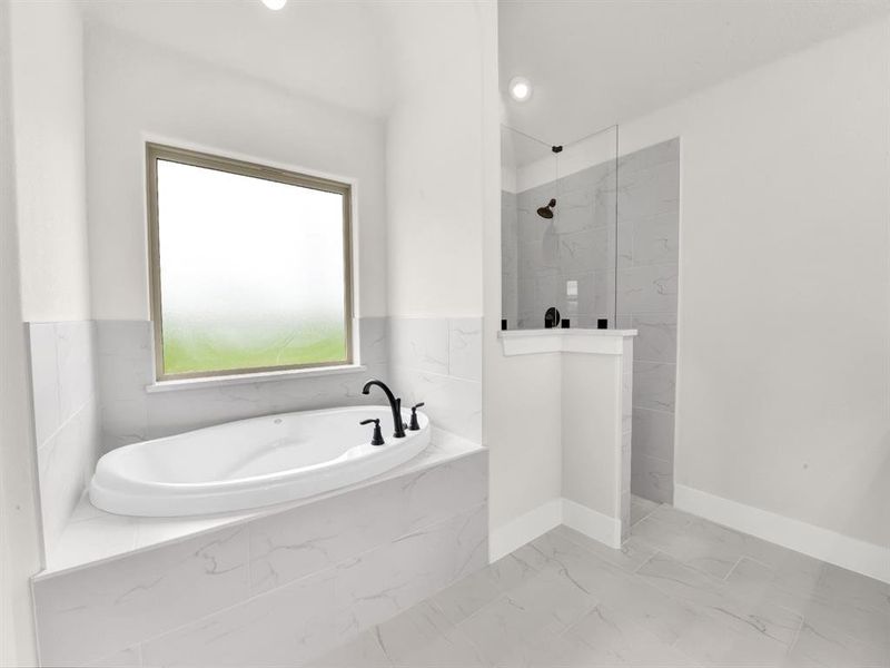 Bathroom featuring a marble finish shower, a garden tub, recessed lighting, and marble look tiles