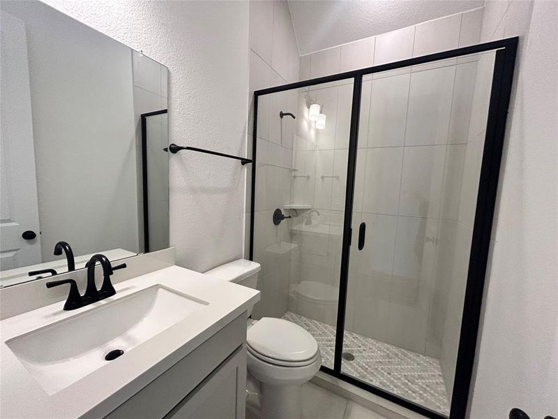 Adjacent to the secondary bedroom, the private bathroom features a stand-up shower for convenience and comfort. Its thoughtful design provides easy access and a modern touch, perfect for guests or family members.