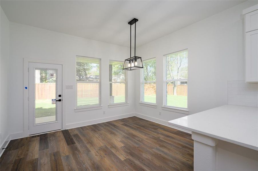 Unfurnished dining area featuring dark hardwood / wood-style flooring