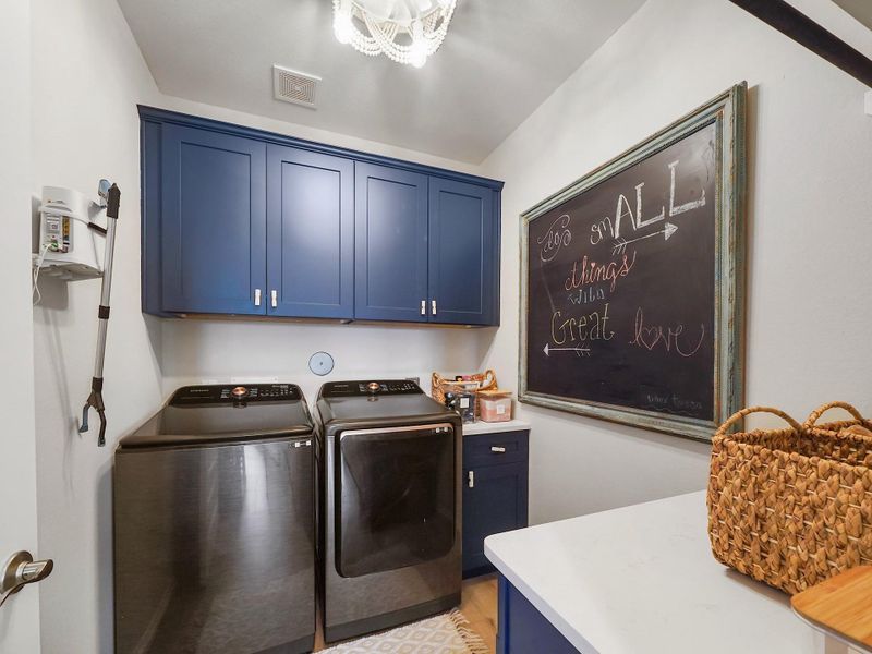 The utility room has been enhanced with custom cabinetry, adding both style and practical storage to this everyday space.