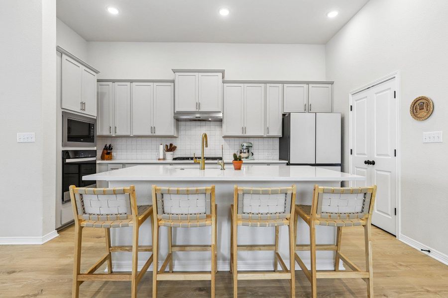 Culinary creations come to life in this kitchen, featuring an expansive island with breakfast bar seating.
