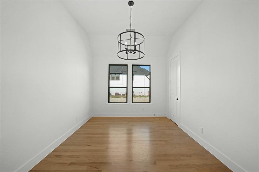 Empty room with a chandelier and light wood-type flooring Empty room with a chandelier and light wood-type flooring
