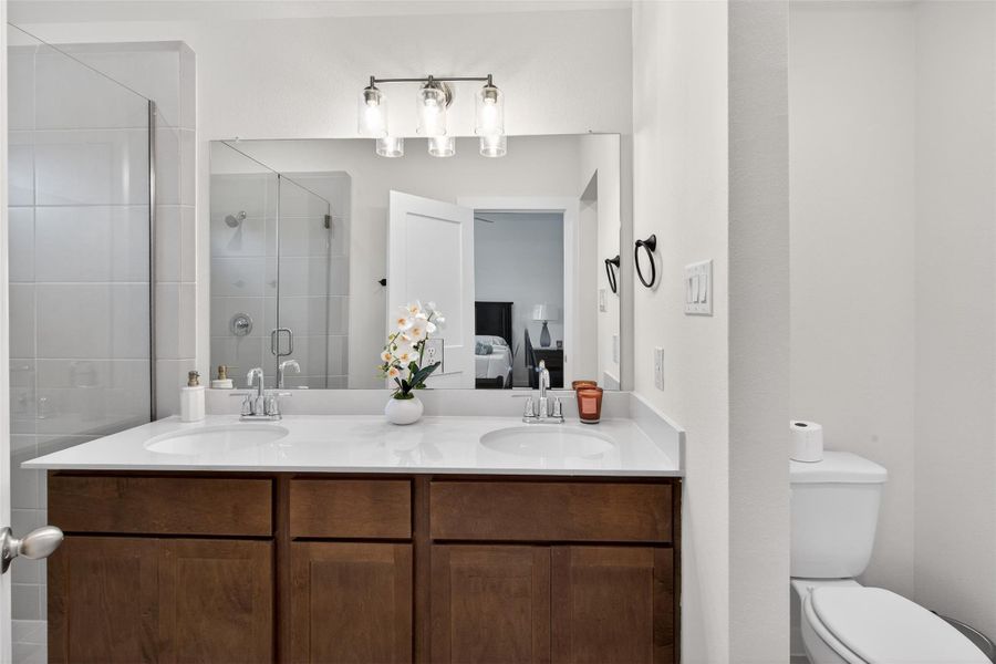 Well-appointed primary bath showcasing a dual-sink vanity, quartz countertops, and modern lighting for a clean, sophisticated look. Well-appointed primary bath showcasing a dual-sink vanity, quartz countertops, and modern lighting for a clean, sophisticated look.