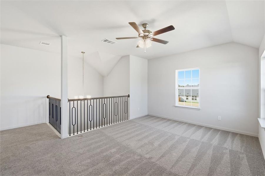 Bonus room with lofted ceiling, a ceiling fan, and carpet floors