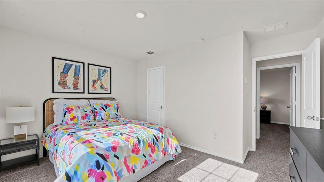 The room features neutral-toned walls, gray carpeting, and a white interior door The room features neutral-toned walls, gray carpeting, and a white interior door