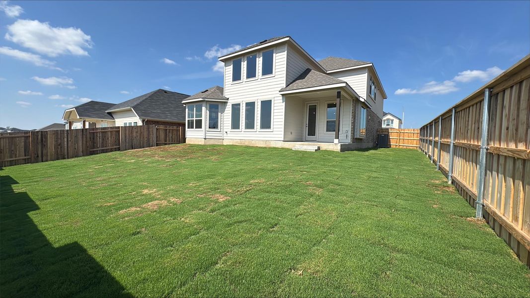 Back of house featuring a shingled roof, a patio, and a fenced backyard