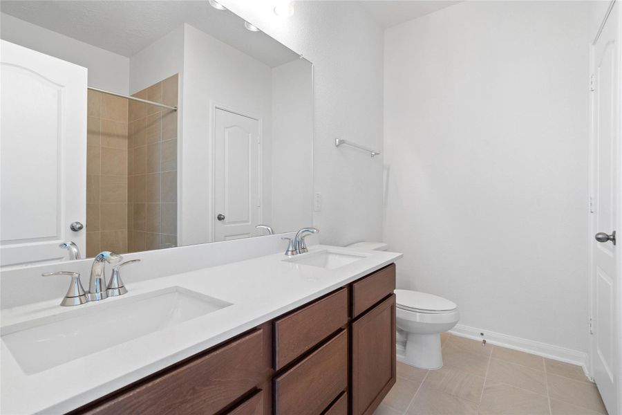 This primary bathroom is definitely move-in ready! Featuring stained cabinets with light countertops, dual sinks, mirror, neutral paint, and sleek modern finishes. This primary bathroom is definitely move-in ready! Featuring stained cabinets with light countertops, dual sinks, mirror, neutral paint, and sleek modern finishes.