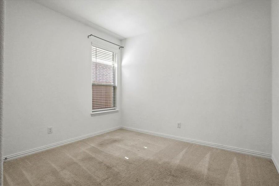 Carpeted spare room featuring baseboards Carpeted spare room featuring baseboards