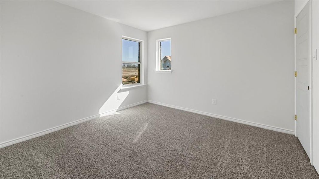 Carpeted spare room featuring baseboards