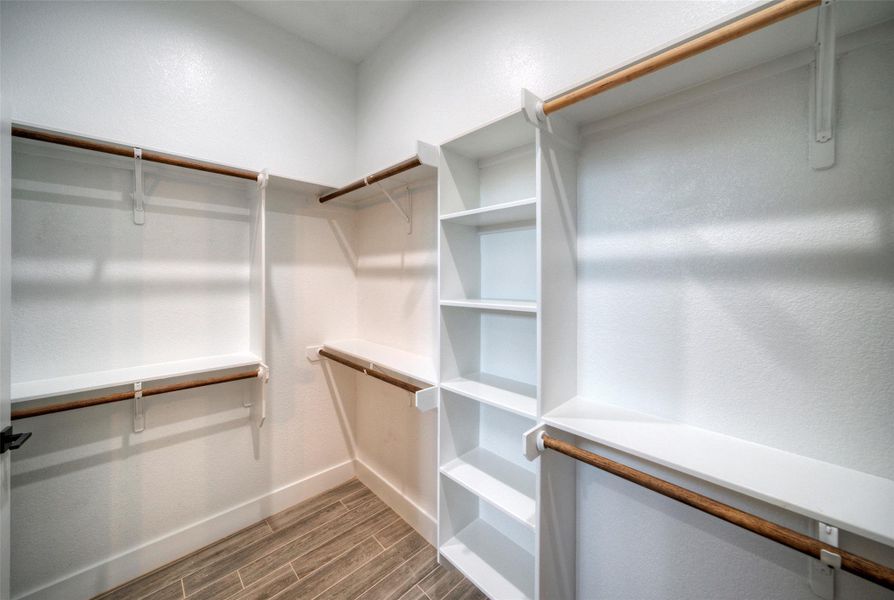 Custom built-in shelving and dual hanging rods maximize storage space on textured tile flooring. Custom built-in shelving and dual hanging rods maximize storage space on textured tile flooring.