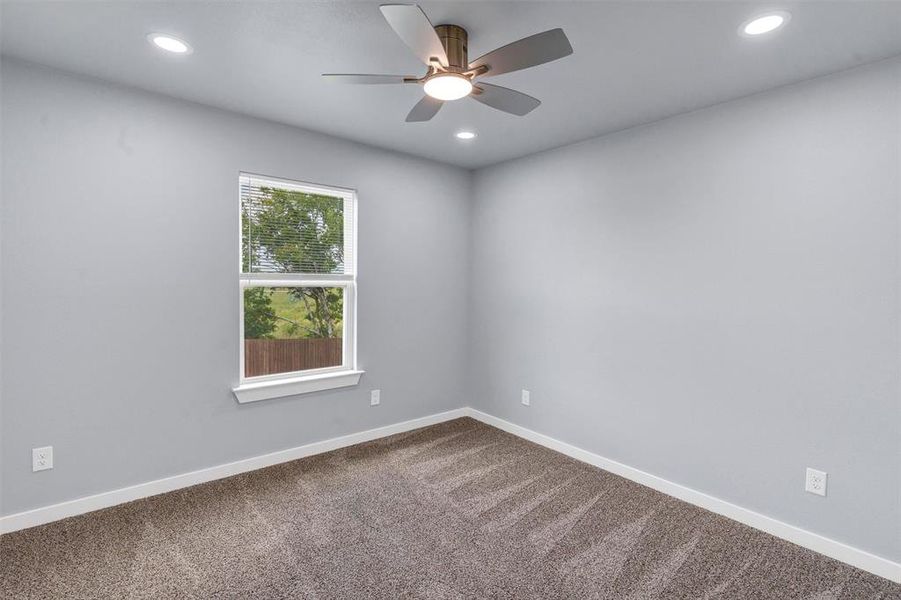 Unfurnished room with a ceiling fan, recessed lighting, and dark colored carpet