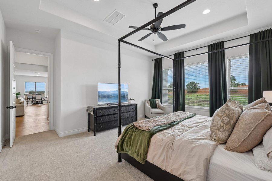 Carpeted room featuring a tray ceiling, recessed lighting, and a ceiling fan