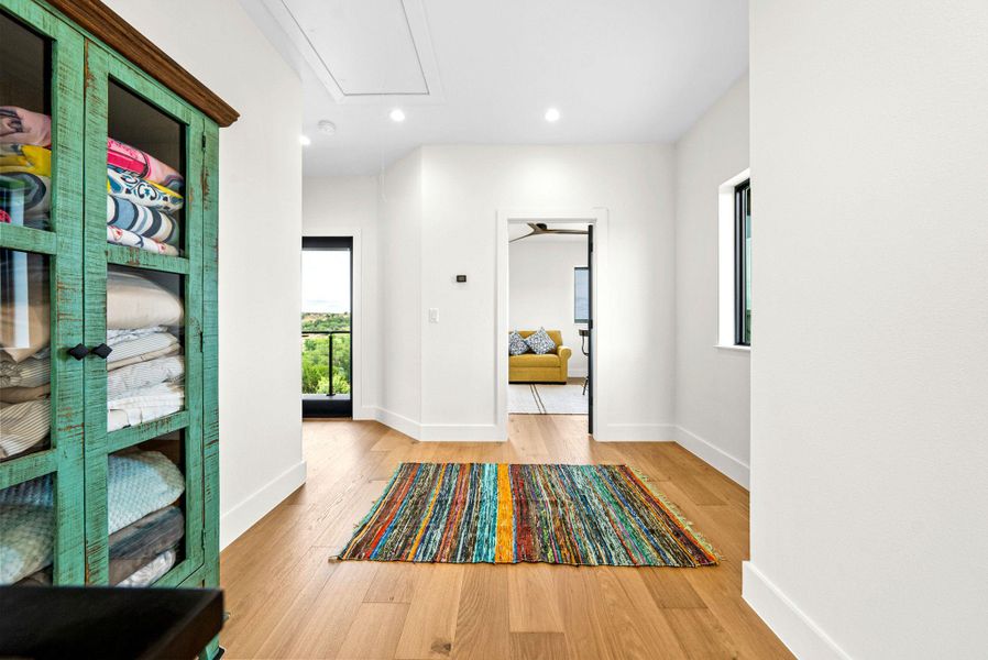 Rich hardwood floors and recessed lighting anchor this bright second-floor landing.
