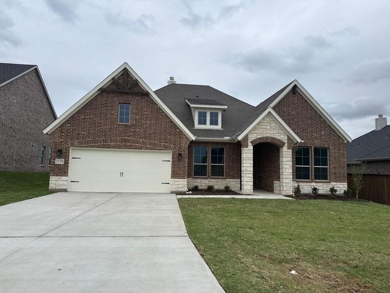 Front exterior of a new home in Covenant Springs, Springtown, TX, highlighting curb appeal (Image 2). Front exterior of a new home in Covenant Springs, Springtown, TX, highlighting curb appeal (Image 2).