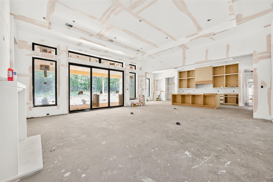 View of family room from hallway leading to the second bedroom. Entrance to the covered patio is equipped with a 3 panel stackable glass slider door.