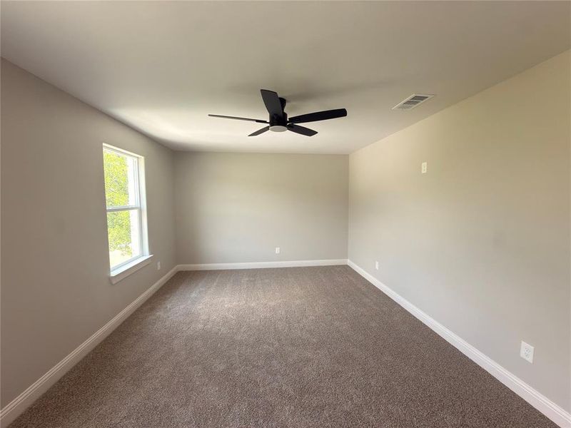 Neutral-toned room featuring broadloom carpeting and a white trim baseboard