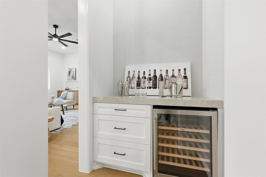 Designed with entertaining in mind, the dry bar offers a Veego beverage refrigerator, generous storage, and a subtle stucco accent wall that adds depth and character.