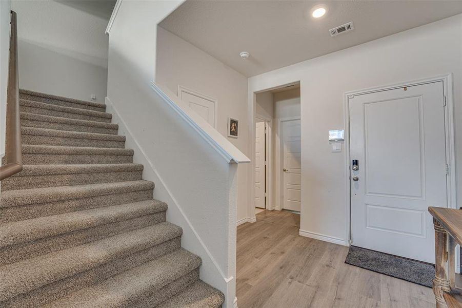 Entryway with stairway, light wood-style flooring, and recessed lighting