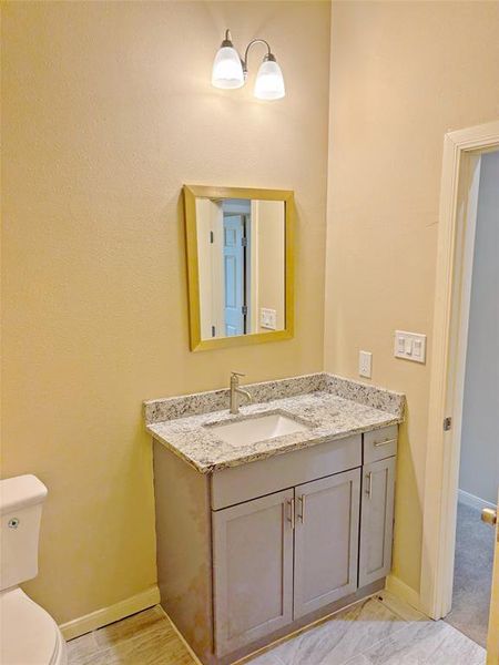 Half bathroom featuring vanity and toilet