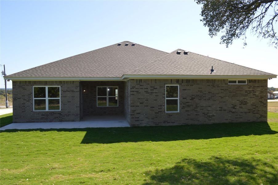 Rear view of property with a patio area, brick siding, a lawn, and roof with shingles Rear view of property with a patio area, brick siding, a lawn, and roof with shingles