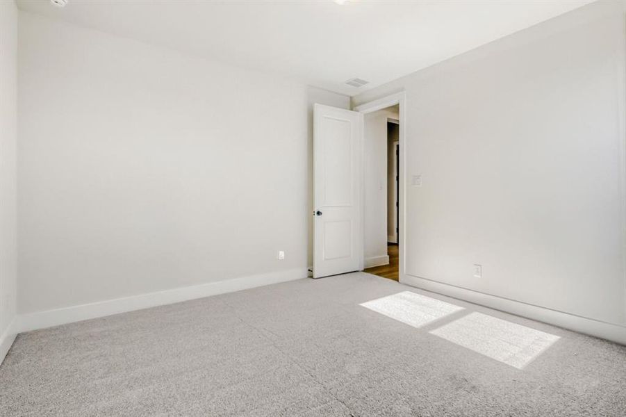 Unfurnished room featuring light carpet and baseboards