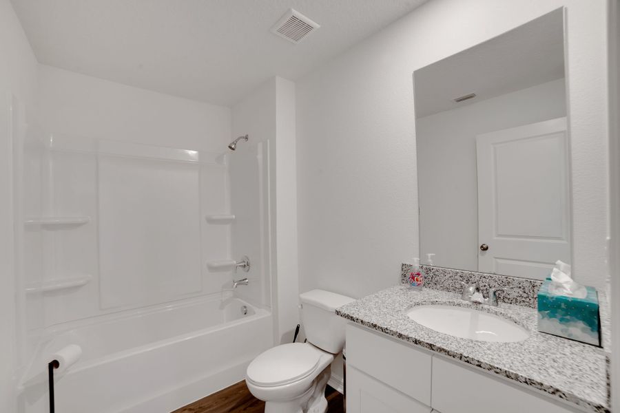 A bathroom with a tub sink and toilet.