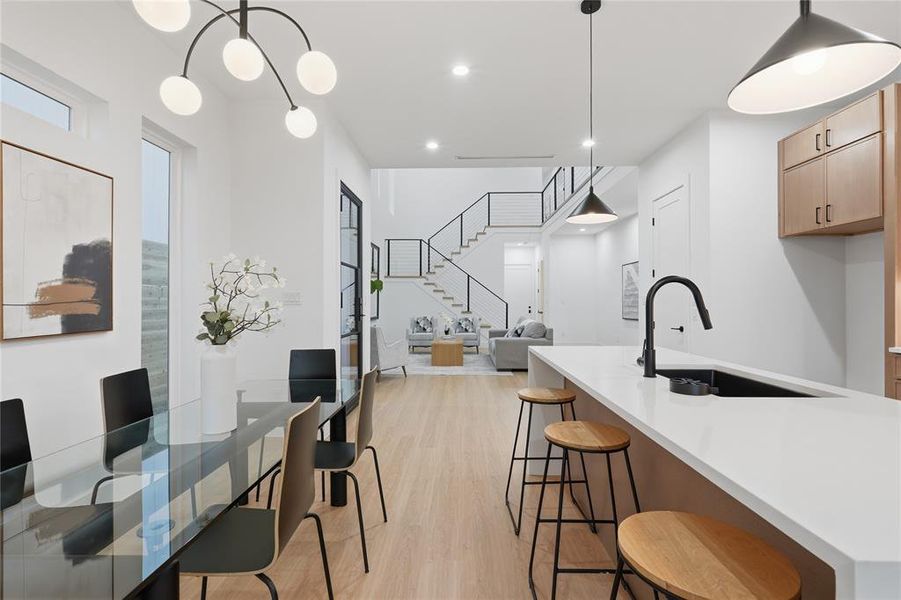 Kitchen with light wood-style floors, a kitchen bar, and light stone countertops
