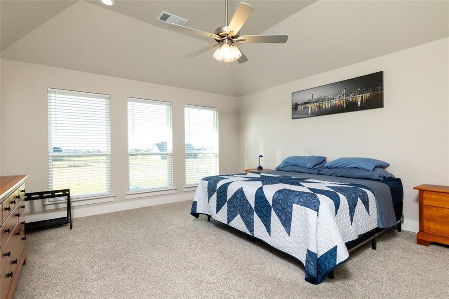 Bedroom featuring light colored carpet, ceiling fan, and lofted ceiling