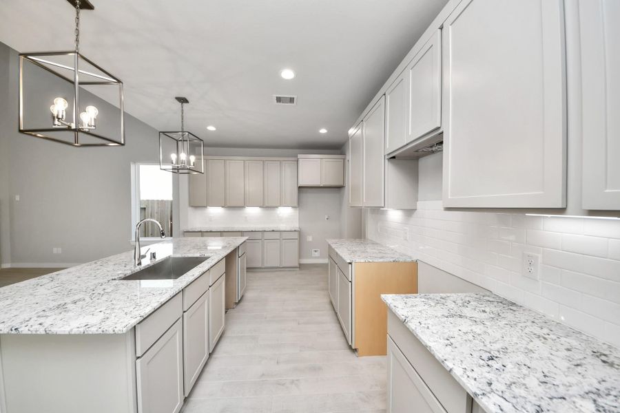 The extended counter area adds both practicality and style, making meal preparation a breeze. Every detail is thoughtfully designed to enhance the kitchen's functionality and aesthetic appeal. Sample photo of completed home with similar floor plan. Actual colors and selections may vary.