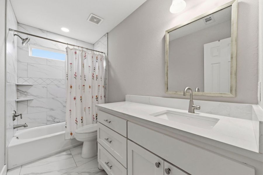 Ceramic tile tub/shower surround adds style and durability to the secondary bathroom.