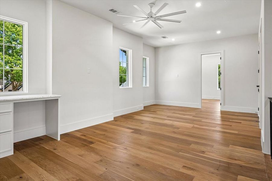 Secondary bedroom, hardwood floors, ceiling fan, built-in desk, multi-window views Secondary bedroom, hardwood floors, ceiling fan, built-in desk, multi-window views