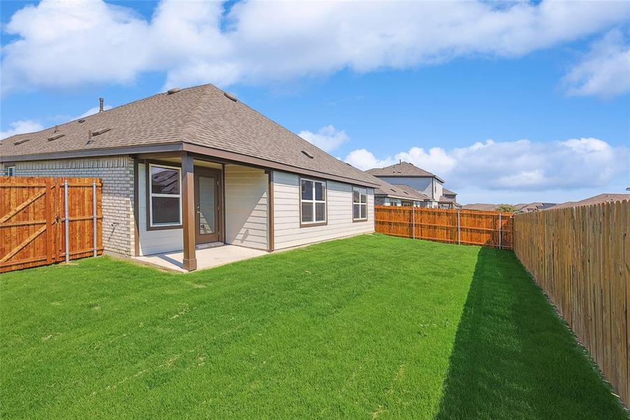 Back of property with a yard and a patio area