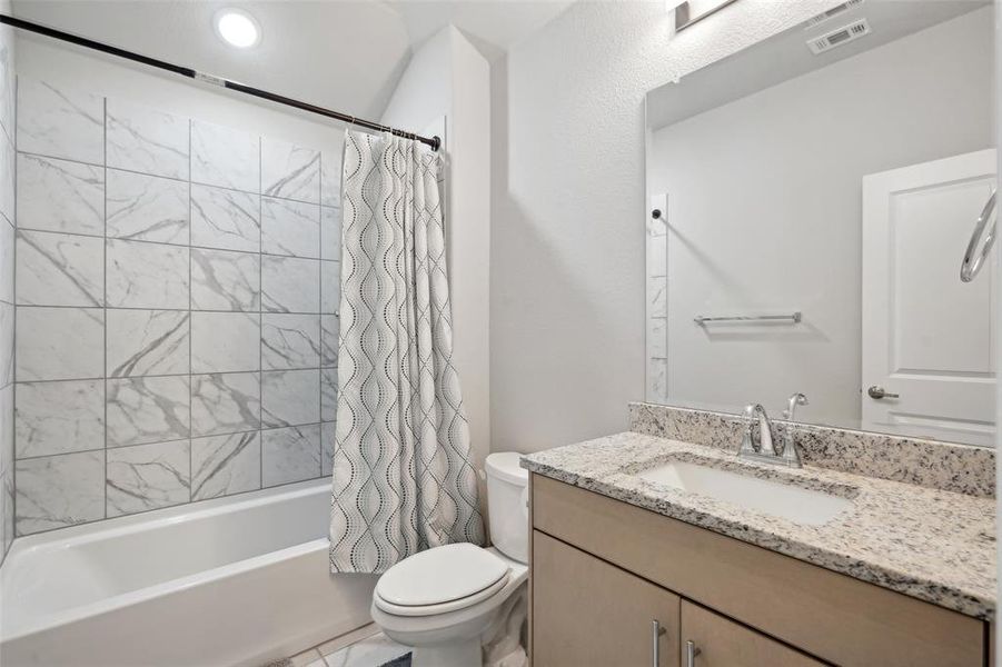 Full bathroom featuring shower / bath combo, vanity, and toilet