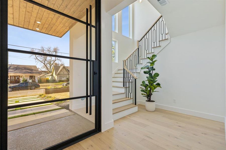 Entryway with wood ceiling, hardwood / wood-style floors, and a high ceiling