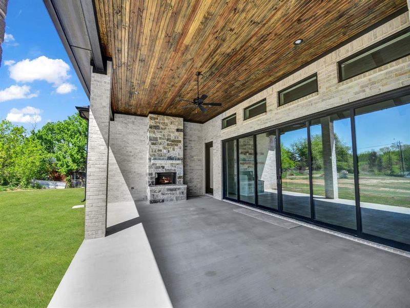 View of patio with a ceiling fan and an outdoor stone fireplace View of patio with a ceiling fan and an outdoor stone fireplace