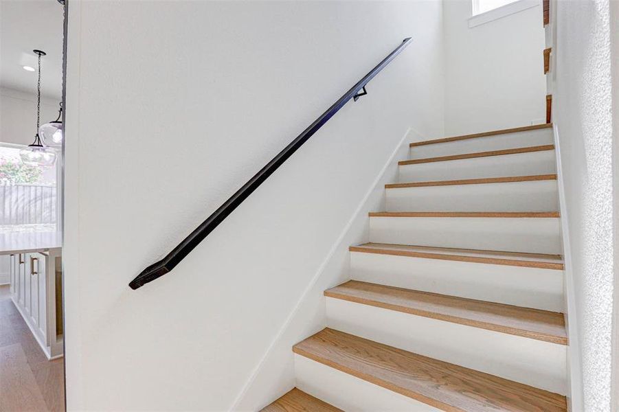 Staircase featuring light hardwood / wood-style flooring and a healthy amount of sunlight