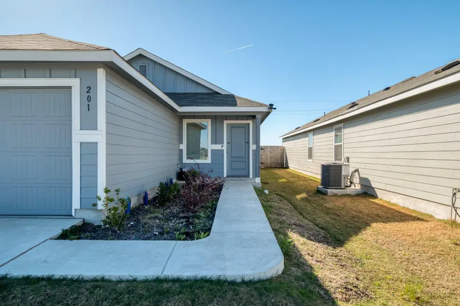 The property features a concrete driveway and walkway, leading to a front entry door with a window