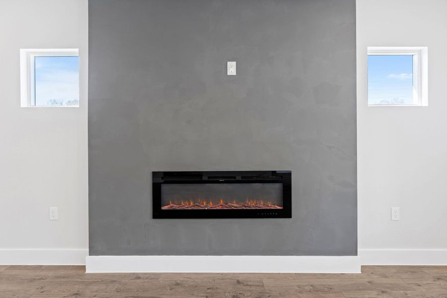 Detailed view of wood finished floors and a glass covered fireplace