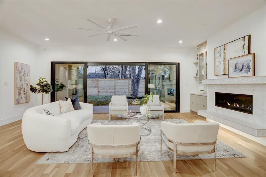 LIVING ROOM: Truly a great room with wide plank, white oak flooring, high ceilings and beautiful feature wall with linear fireplace, LED lit hearth plus polished nickel library lights.  Great storage flanks the fireplace with glass doors and lower cabinets.