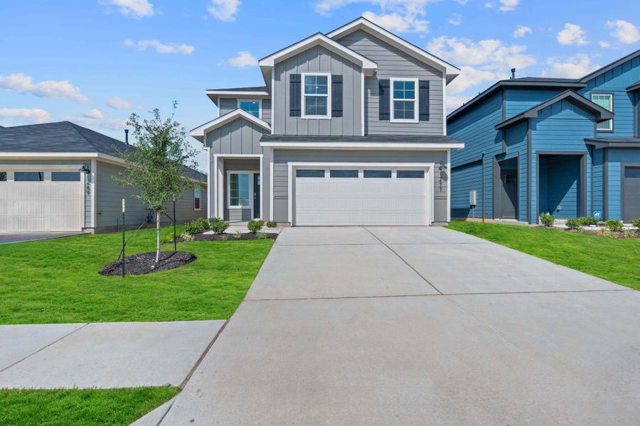 View of front of house featuring board and batten siding, a garage, driveway, and a front lawn View of front of house featuring board and batten siding, a garage, driveway, and a front lawn