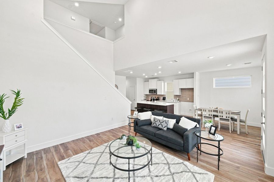 Spacious living room showcasing impressive ceiling height and an open-concept design with clear views into the kitchen and breakfast area. Spacious living room showcasing impressive ceiling height and an open-concept design with clear views into the kitchen and breakfast area.