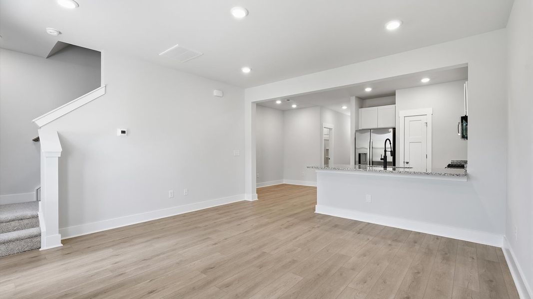 Spacious family room with rich hardwood flooring and elegant trim work in a reputable DRB Homes build Spacious family room with rich hardwood flooring and elegant trim work in a reputable DRB Homes build