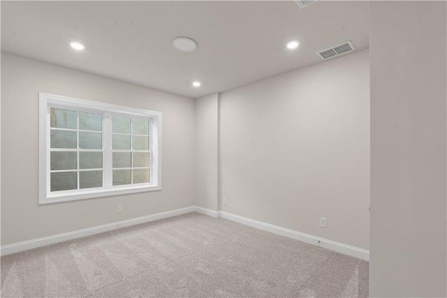Empty room featuring light carpet and recessed lighting