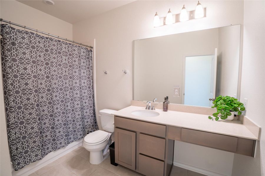 Bathroom featuring a vanity with a light-colored countertop, integrated sink, and brushed nickel faucet Bathroom featuring a vanity with a light-colored countertop, integrated sink, and brushed nickel faucet
