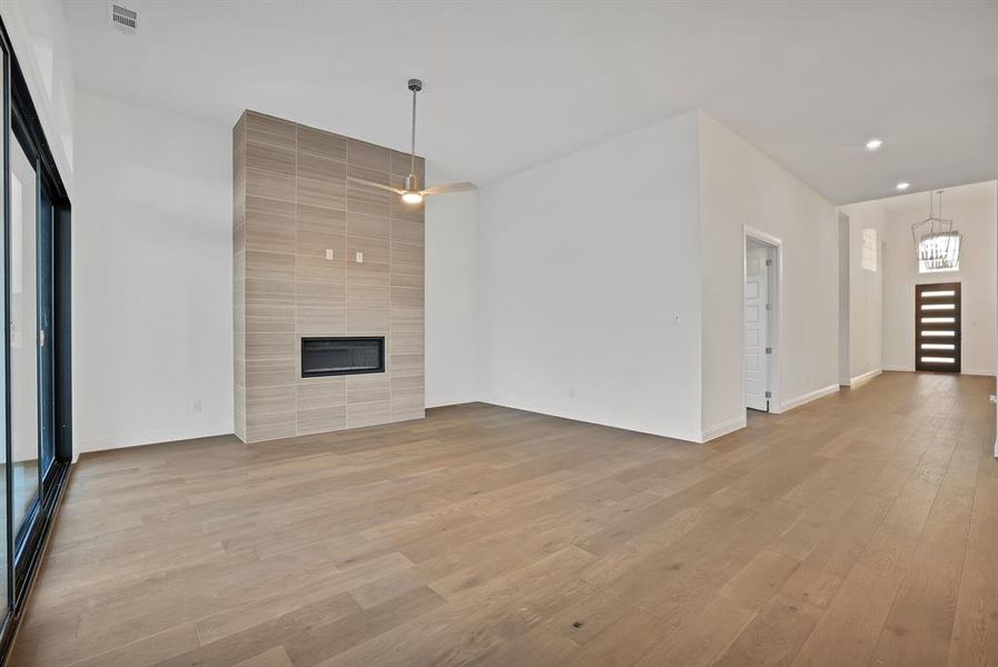 Living room featuring a tiled fireplace and light hardwood / wood-style flooring