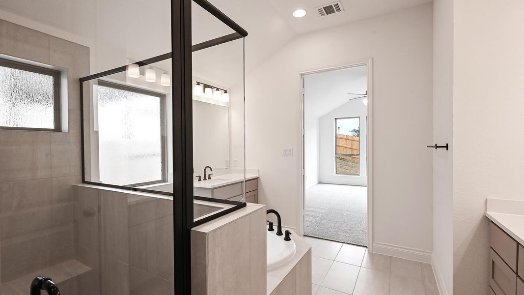 Full bathroom featuring vanity, a bath, a tile shower, tile patterned flooring, and vaulted ceiling Full bathroom featuring vanity, a bath, a tile shower, tile patterned flooring, and vaulted ceiling