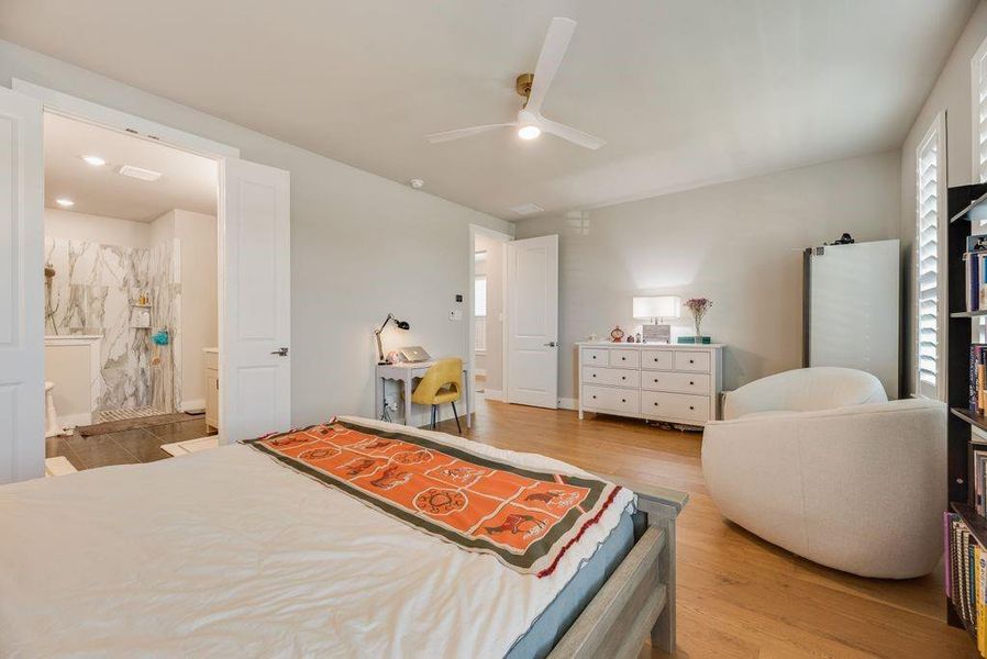 Bedroom featuring light wood finished floors, ceiling fan, ensuite bath, and recessed lighting