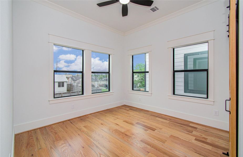 Bright third bedroom features hardwood floors, large windows for natural light.